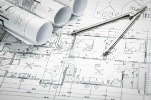 Architectural,blueprints,and,blueprint,rolls,and,a,drawing,instruments,on